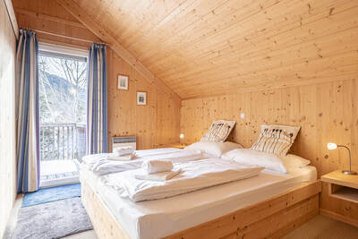 Tweepersoonsbed in een slaapkamer van een chalet op Alps Resorts Almdorf Stadl