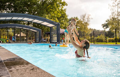 Mensen aan het zwemmen in het buitenbad van Camping de Norgerberg