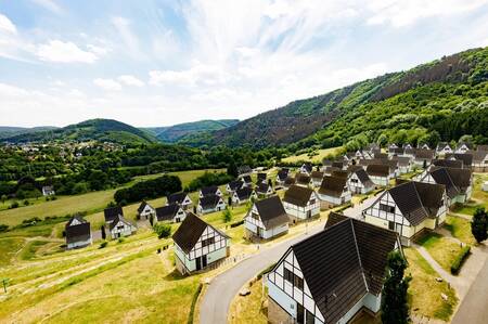 Luchtfoto van vakantiehuizen op vakantiepark Dormio Eifeler Tor in de heuvels van de Eifel