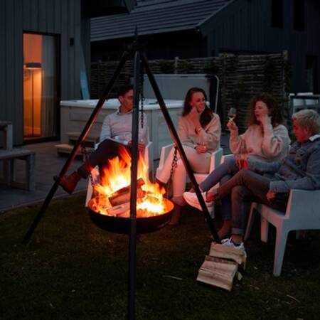 Mensen bij een vuurkorf in de tuin van een vakantiehuis op Dutchen Baayvillas