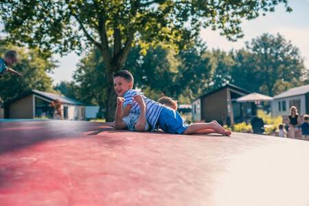 2 kinderen spelen op de airtrampoline in de speeltuin op vakantiepark EuroParcs Kaatsheuvel