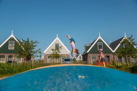 Kinderen springen op de airtrampoline in een speeltuin op vakantiepark EuroParcs Poort van Amsterdam