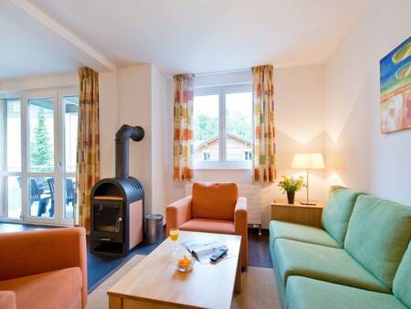 Woonkamer met een houtkachel van een appartement op Landal Alpen Resort Vierwaldstättersee