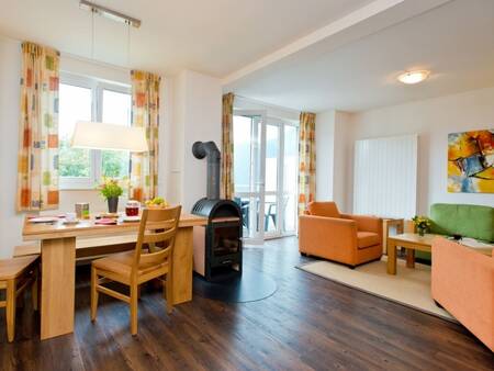 Woonkamer met tafel en houtkachel in een appartement op Landal Alpen Resort Vierwaldstättersee