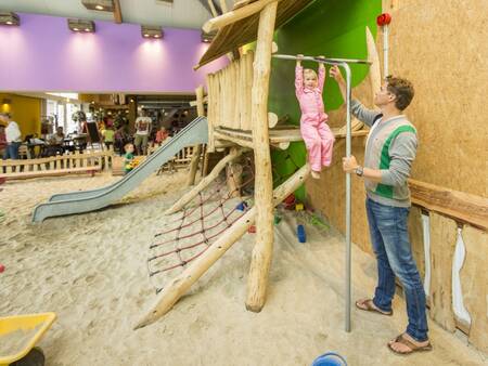 Vader en kind spelen in de indoorspeeltuin van vakantiepark Landal Het Land van Bartje