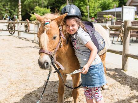 Meisje met een pony op de ponyranch van vakantiepark Landal Het Land van Bartje