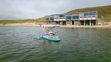 Kinderen aan het suppen in de Noordzee vlakbij Landal Residence Berger Duinen