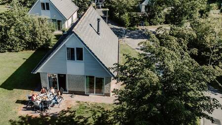 Gezin in de tuin van een vrijstaand vakantiehuis op Landgoed Ruwinkel