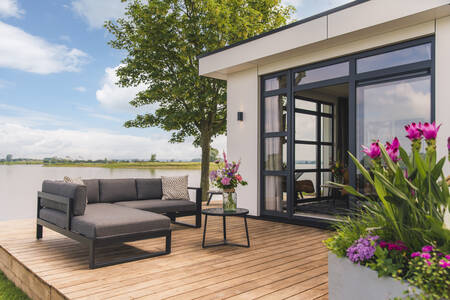 Loungeset op een vlonder van een vakantiehuis aan het water op MarinaPark Bad Nederrijn