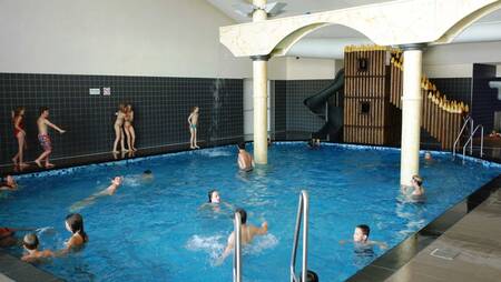 Mensen aan het zwemmen in het binnenbad van vakantiepark Molecaten Park Noordduinen
