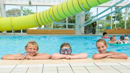 Kinderen in het zwembad met 25 meter lange glijbaan van vakantiepark Molecaten Park Wijde Blick