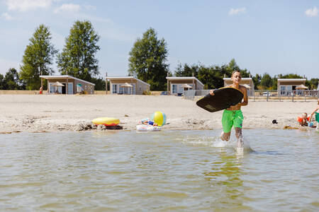 Jongen rent door het water van het Veluwemeer op vakantiepark RCN Zeewolde