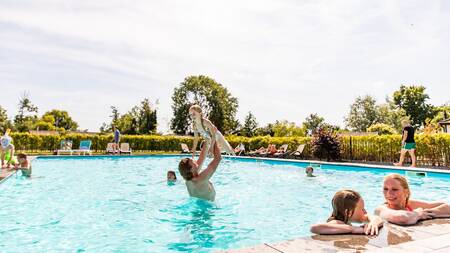 Mensen aan het zwemmen in het buitenbad van vakantiepark Topparken Parc de IJsselhoeve